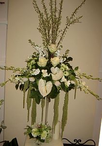 Corporate arrangement made of white anthurium, white roses, orhids, dendrobium, santini, freesia,etc